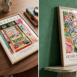Framed Henri Matisse art prints displayed on a table and wall.