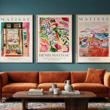 Living room with a brown sofa, coffee table, and three Matisse art prints on the wall.