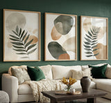 Living room with a beige sectional sofa, decorative pillows, and framed abstract art on a green wall.